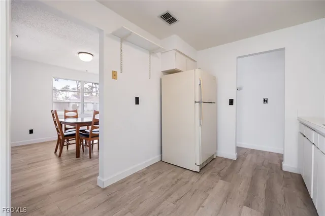 a view of a dining room with hardwood floor and an entrance door