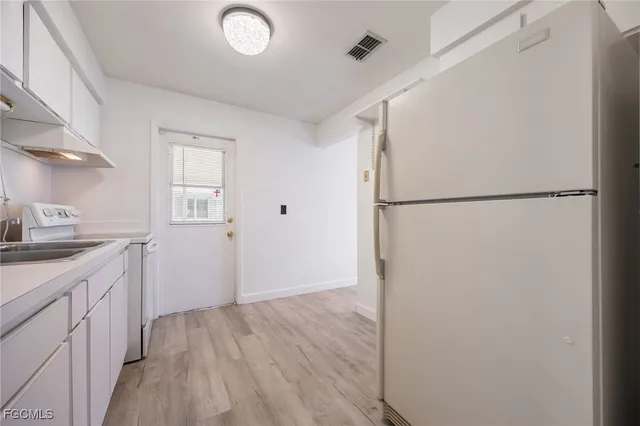 a view of a kitchen with a sink and a refrigerator