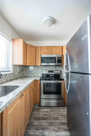 a kitchen with stainless steel appliances granite countertop a stove a sink and a refrigerator
