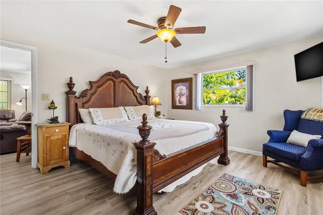 a bedroom with a bed a couch and a chandelier