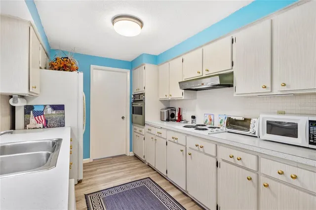 a kitchen with stainless steel appliances granite countertop a sink and a refrigerator