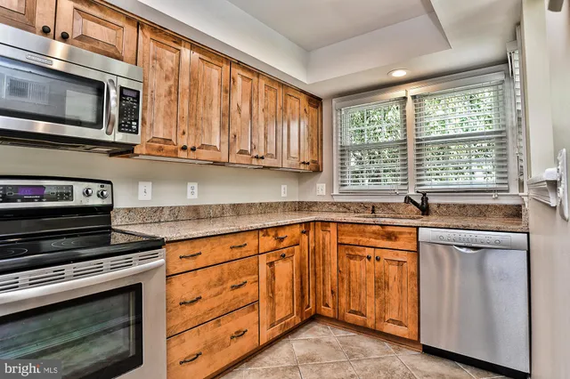 a kitchen with stainless steel appliances granite countertop a stove microwave and cabinets