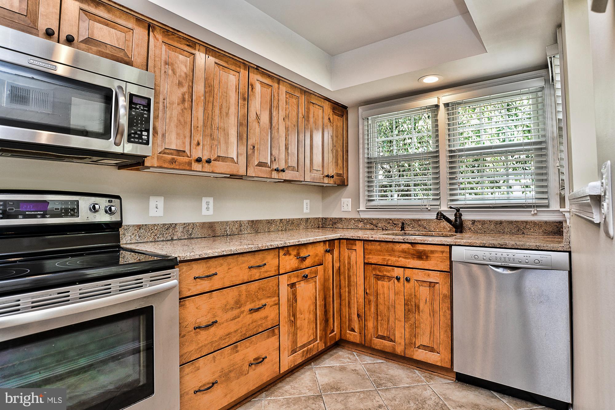 12817 Mill Brook Court Woodbridge, VA 22192 - Photo 12 of 34 a kitchen with stainless steel appliances granite countertop a stove microwave and cabinets