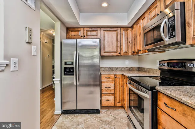 a kitchen with stainless steel appliances granite countertop a refrigerator a stove a sink and dishwasher