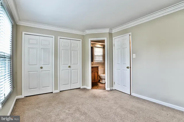 an empty room with windows and closet