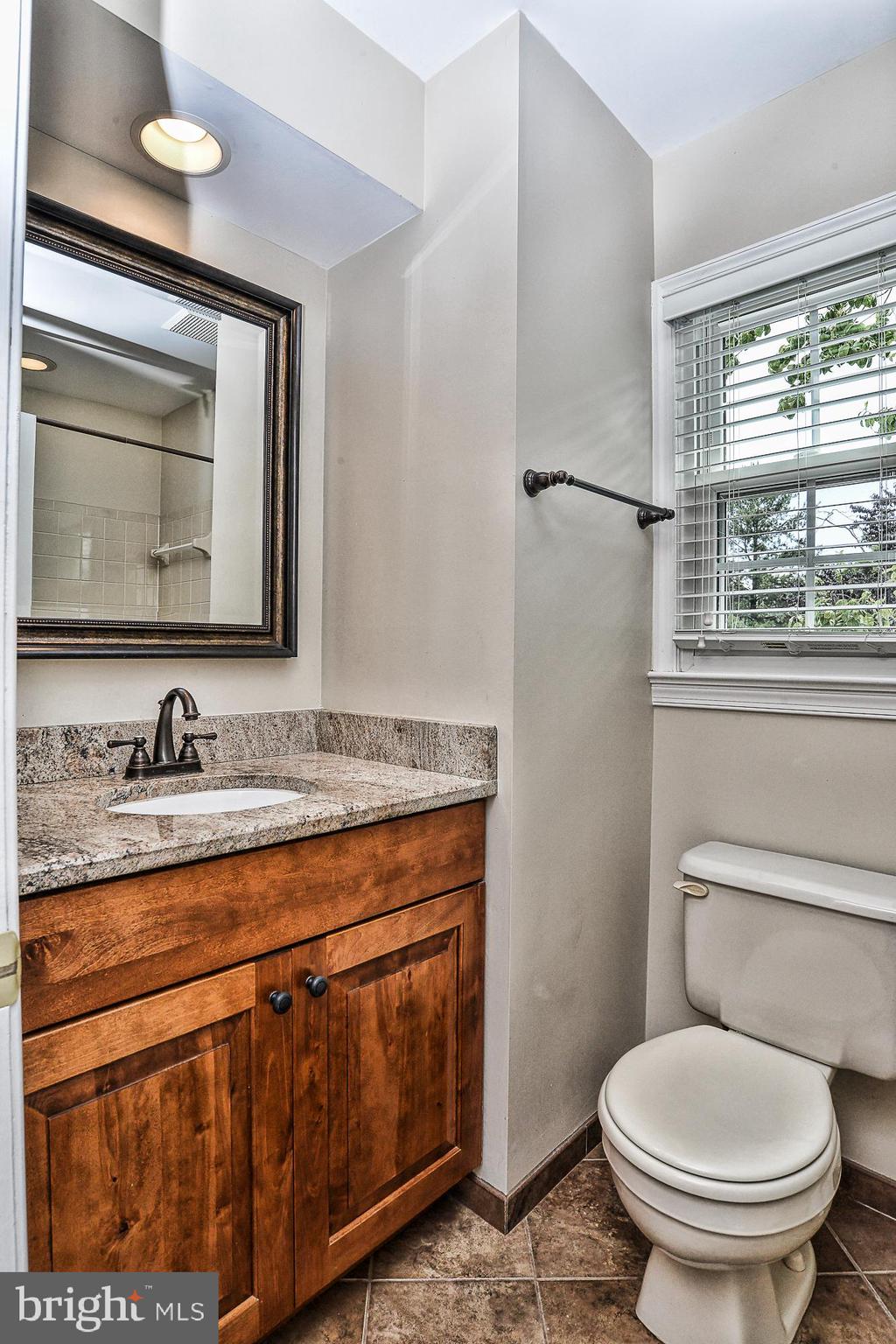12817 Mill Brook Court Woodbridge, VA 22192 - Photo 21 of 34 a bathroom with a granite countertop toilet sink and mirror