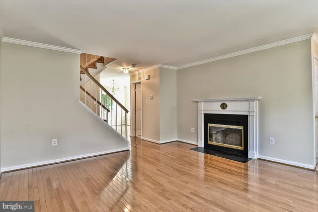 a view of a livingroom with wooden floor and a fireplace