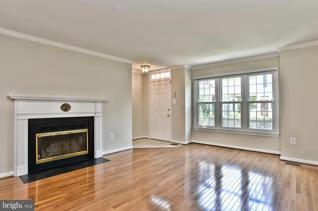 a view of an empty room with exposed radiator and fireplace