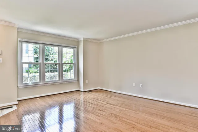 wooden floor in an empty room with a window
