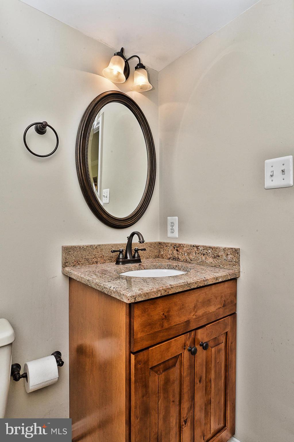 12817 Mill Brook Court Woodbridge, VA 22192 - Photo 9 of 34 a bathroom with a granite countertop sink a mirror and toilet