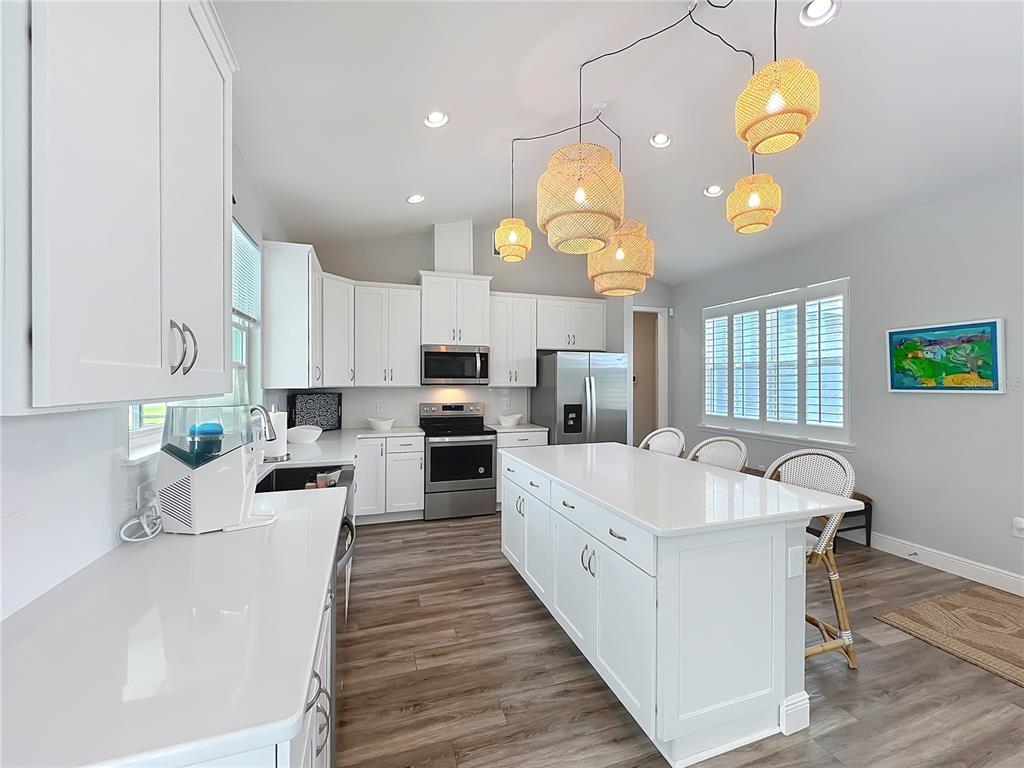 10220 Bay Lake Road Groveland, FL 34736 - Photo 51 of 67 a large white kitchen with lots of counter space and chandelier