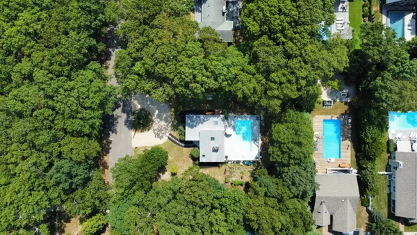 an aerial view of a house with swimming pool and garden