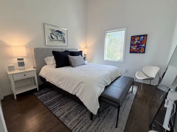 a bedroom with a bed and a painting on the wall