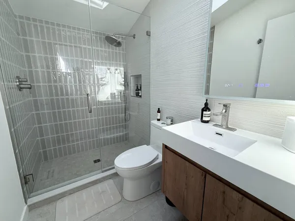 a bathroom with a sink a toilet and shower