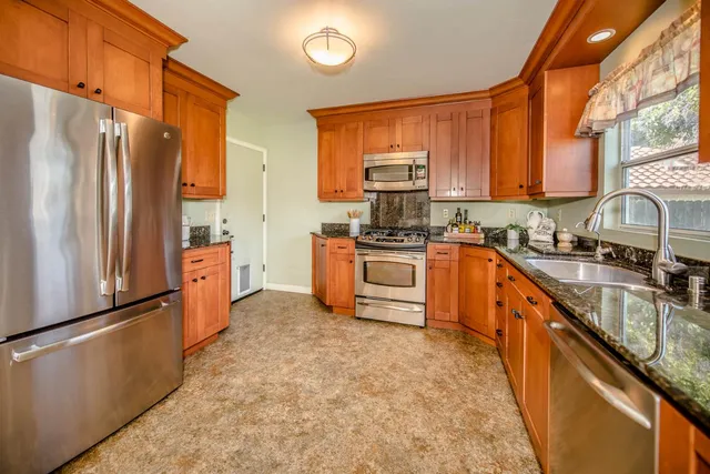 a kitchen with granite countertop a sink and a wooden floor
