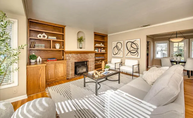 a living room with furniture a fireplace and a window