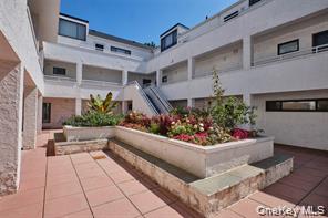 21 Canterbury Road, Unit 6 Great Neck, NY 11021 - Photo 1 of 32 a view of a patio with dining table and chairs
