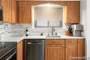 21 Canterbury Road, Unit 6 Great Neck, NY 11021 - Photo 11 of 32 a kitchen with stainless steel appliances a sink stove and cabinets