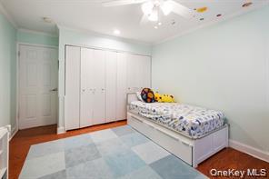 21 Canterbury Road, Unit 6 Great Neck, NY 11021 - Photo 25 of 32 a bedroom with a bed and a window