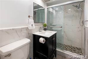 21 Canterbury Road, Unit 6 Great Neck, NY 11021 - Photo 26 of 32 a bathroom with a sink a toilet and shower