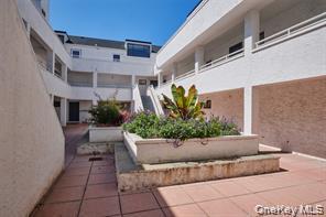 21 Canterbury Road, Unit 6 Great Neck, NY 11021 - Photo 29 of 32 a view of a chairs and table in the back yard of the house