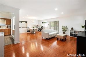 21 Canterbury Road, Unit 6 Great Neck, NY 11021 - Photo 3 of 32 a living room with furniture and a table with wooden floor