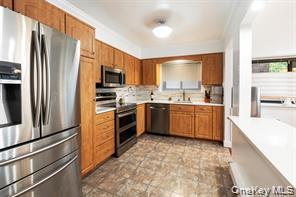 21 Canterbury Road, Unit 6 Great Neck, NY 11021 - Photo 9 of 32 a kitchen with stainless steel appliances a sink cabinets and a window