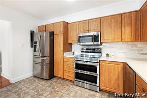 21 Canterbury Road, Unit 6 Great Neck, NY 11021 - Photo 10 of 32 a kitchen with granite countertop a refrigerator stove and microwave
