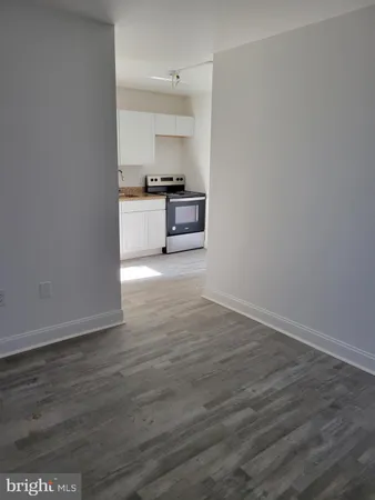 a view of a kitchen with wooden floor and electronic appliances
