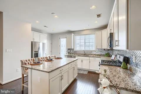 a kitchen that has a lot of cabinets a sink and appliances