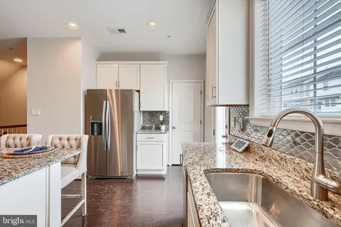 a large kitchen with a table and chairs