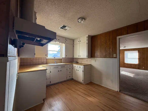 a kitchen with sink cabinets and wooden floor
