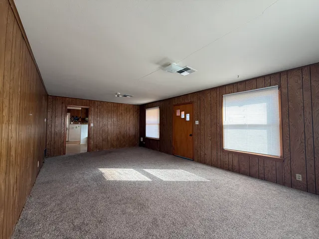 an empty room with windows and closet