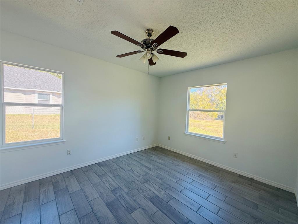 255 7th Street Southwest Paris, TX 75460 - Photo 13 of 17 a view of an empty room with wooden floor and a window