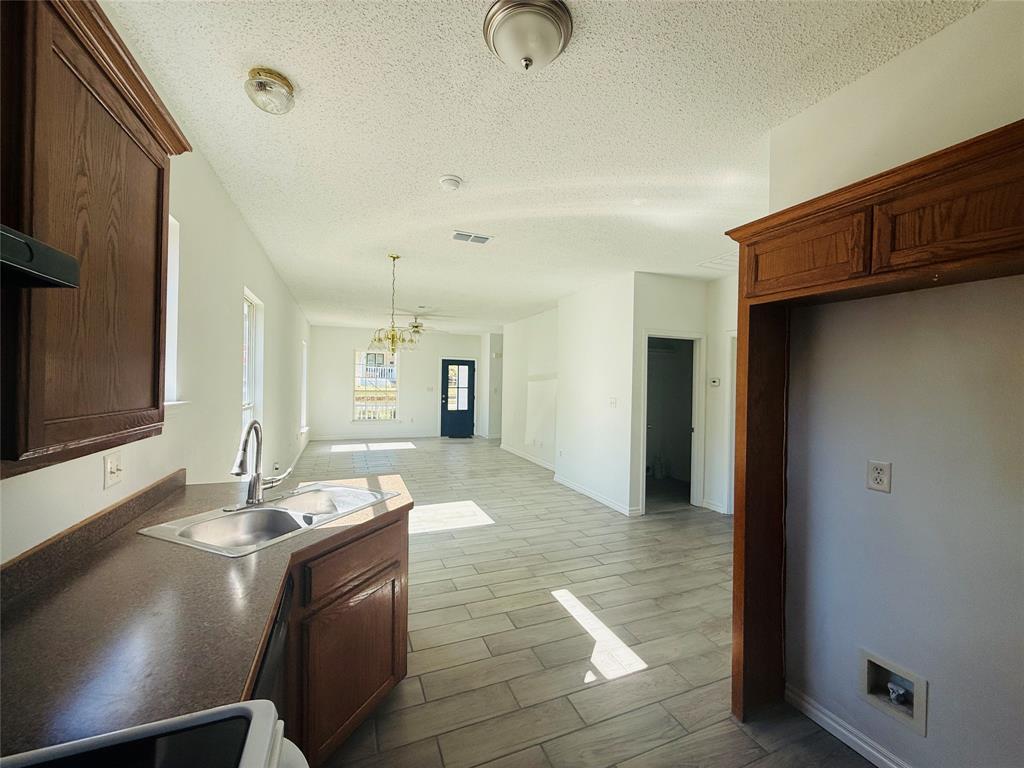 255 7th Street Southwest Paris, TX 75460 - Photo 7 of 17 a kitchen with granite countertop a sink cabinets and stainless steel appliances