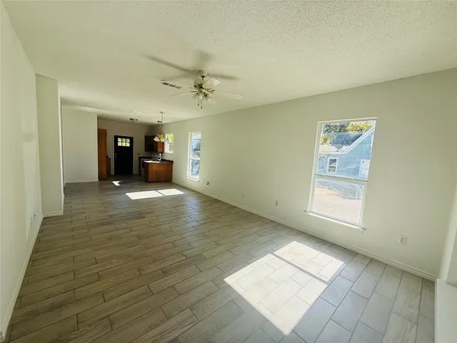 a view of a big room with wooden floor and windows
