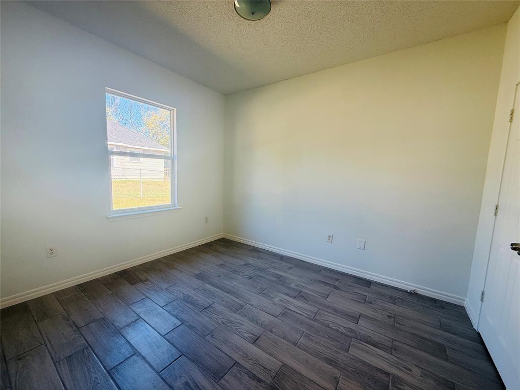 255 7th Street Southwest Paris, TX 75460 - Photo 10 of 17 an empty room with wooden floor and windows