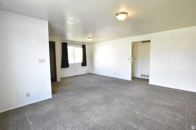 290 West 600 North Logan, UT 84321 - Photo 45 of 45 Spacious room featuring gray carpet, white walls, and a large window with black window treatments