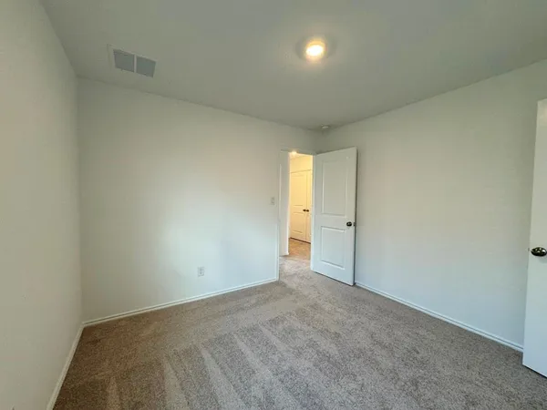 an empty room that has a wooden cupboard