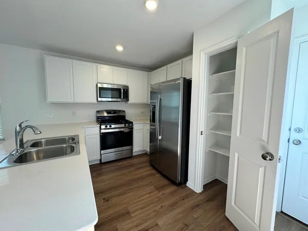 a kitchen with granite countertop a refrigerator and a sink