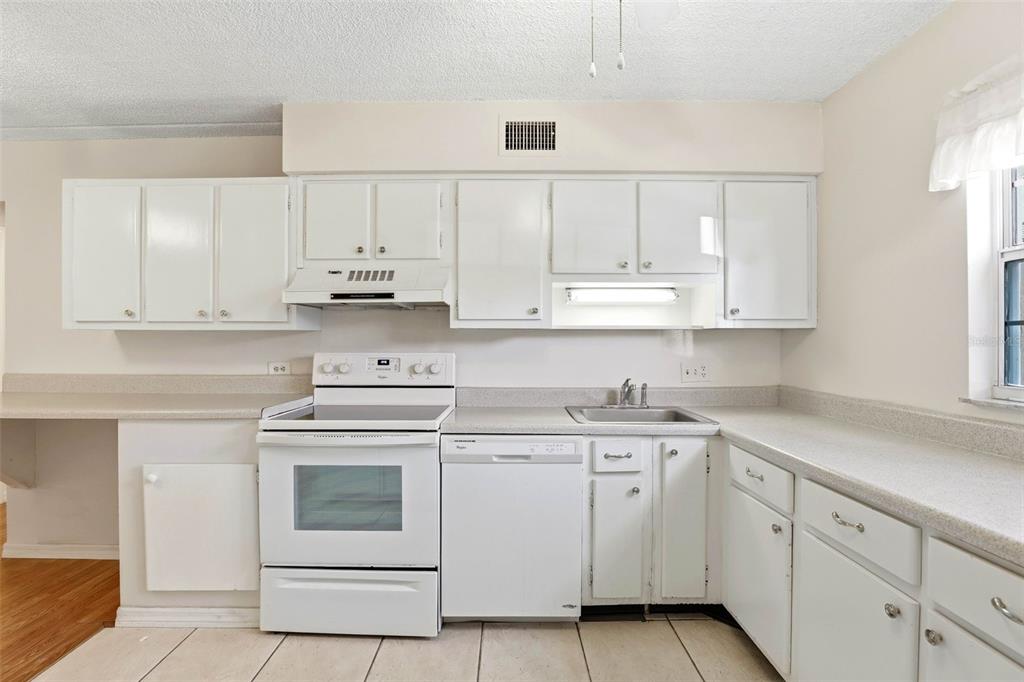 525 South Conway Road, Unit 69 Orlando, FL 32807 - Photo 13 of 25 a kitchen with white cabinets and white appliances