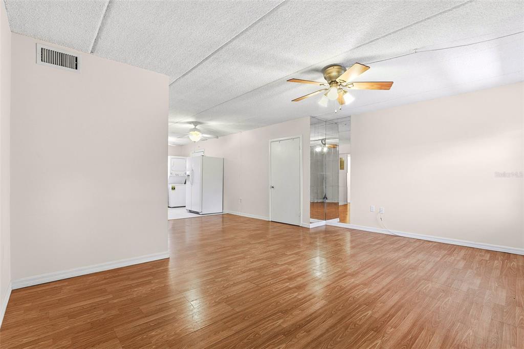 525 South Conway Road, Unit 69 Orlando, FL 32807 - Photo 7 of 25 a view of an empty room with wooden floor and a ceiling fan