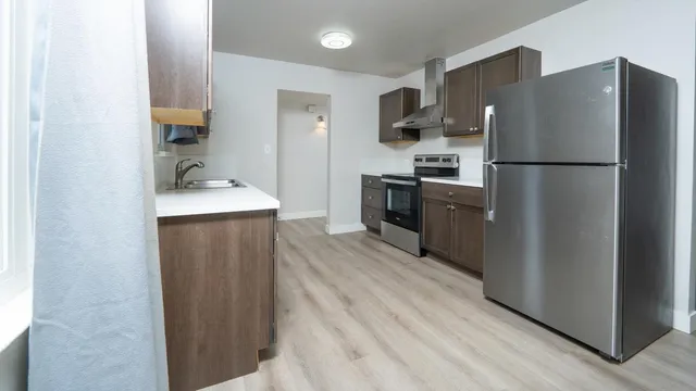a kitchen with a refrigerator a stove top oven and a refrigerator