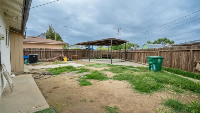 a view of a yard with a table and chairs under an umbrella