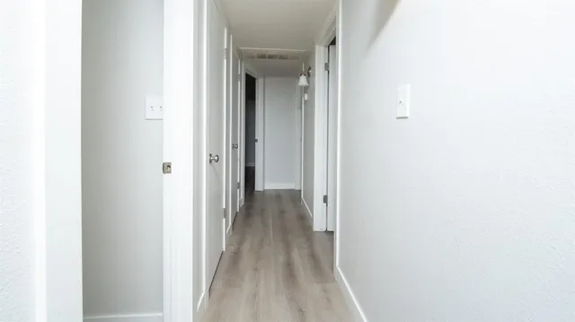 a view of a hallway with wooden floor