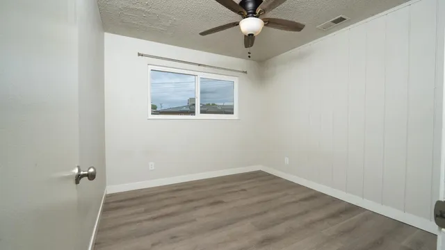 an empty room with a window and a ceiling fan