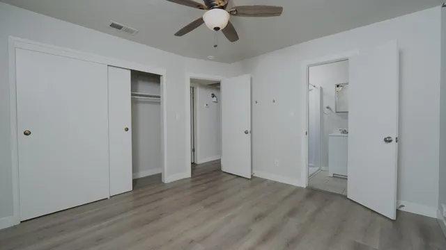 a view of empty room with wooden floor and ceiling fan