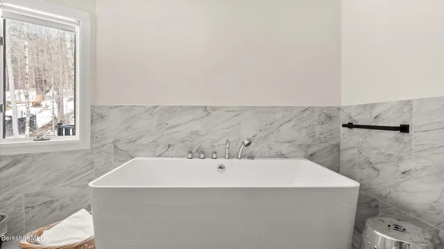 a bathroom with a bathtub and a window