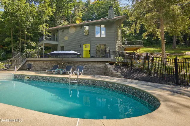 a view of a house with pool yard and sitting area
