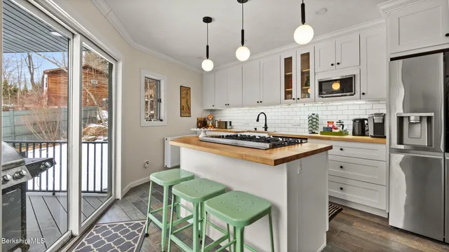 a kitchen with stainless steel appliances granite countertop a stove a sink a refrigerator and a refrigerator with wooden floor